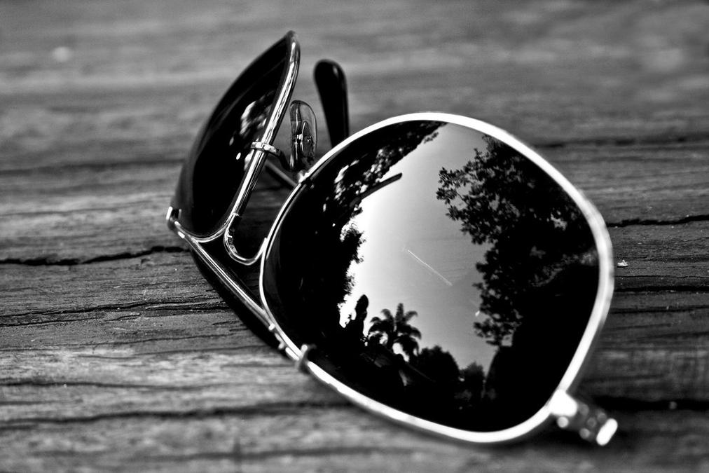 Reflection - a pair of sunglasses sitting on top of a wooden table